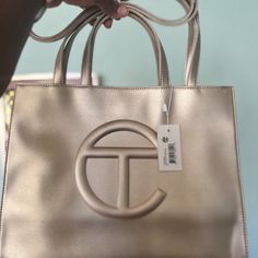 Nwt Telfar Medium Shopping Bag In The Color Gold. Original Packaging And Dust Bag Included. Height 11 1/4", Width 15", Depth 5", Strap Drop 21", Handle Drop 5 1/2" Reasonable Offers Accepted Gold Shoulder Bag With Branded Hardware And Double Handle, Designer Gold Bags With Double Handle, Designer Gold Double Handle Bag, Tan Tote Bag With Branded Hardware, Gold Bags With Branded Hardware And Double Handle, Gold Top Handle Bag With Branded Hardware, Gold Double Handle Bag With Dust Bag, Gold Shoulder Bag With Branded Hardware, Tan Tote Bag With Gold-tone Hardware