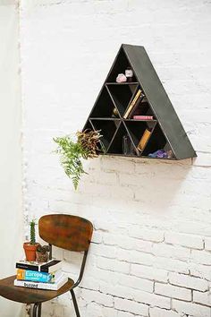 a chair and table in front of a white brick wall with a shelf on it