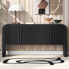 a black and gold sideboard in front of a wall with art work on it