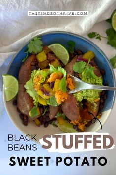 a blue bowl filled with black beans, sweet potato salad and topped with lime wedges