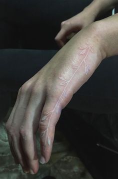 a person's hand with white paint on it and an arrow drawn on the arm