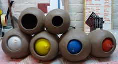 five vases sitting on top of a table next to each other in front of a brick wall