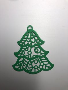 a green christmas tree ornament sitting on top of a refrigerator