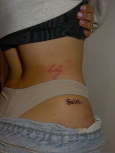 a woman's stomach with the word saint written on her lower back and side