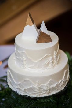 a white wedding cake with mountains on top