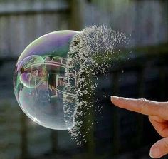 a person is holding a soap bubble in their hand