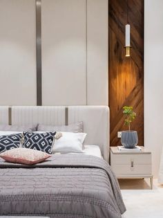 a white bed sitting next to a wooden wall