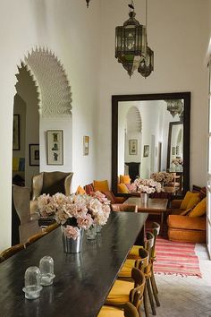 a living room filled with lots of furniture and flowers in vases on the table