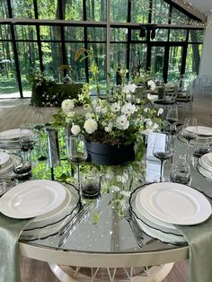 the table is set with white plates and silverware