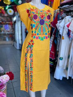 "100% Authentic Mexican Dress  This Dress is gorgeous. Once size fit up to S Color: yellow  Size:Small Please check measurements to make sure is the size you need. Chest: 20\" Waist: 20\" Sholder:20\" Sholder to hem:48\" the floral wall remain the same but the embroidery colors vary on each dress Ebroidery Mexican Dress.Boho Chic Dress Folk Fabric Flowers Mexican Tunic Traditional Embroidery This Dress is perfect for those beach day or any occasion This Dress is meant to provide extreme comfort throughout the day The perfect gift for her" Yellow Cotton Midi Dress With Short Sleeves, Yellow Cotton Knee-length Dress, Folk Fabric, Mexican Dress, Traditional Embroidery, Boho Chic Dress, Mexican Dresses, Authentic Mexican, Dress Boho