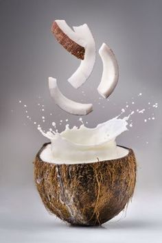 a coconut with milk splashing out of it