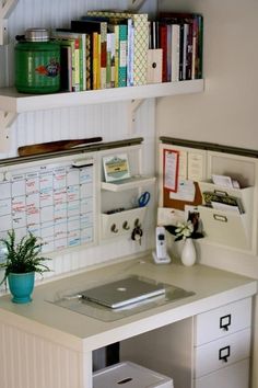 a desk with a laptop computer on top of it next to a bookshelf