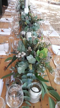 a long table with candles and greenery on it