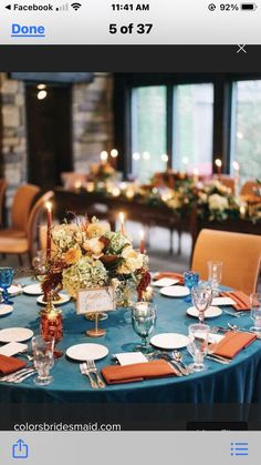 a table set up with place settings and flowers on it for an elegant dinner party