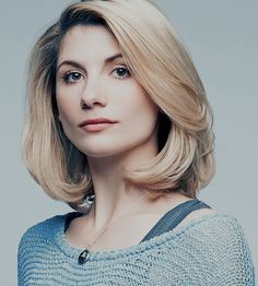 a woman with blonde hair wearing a blue sweater