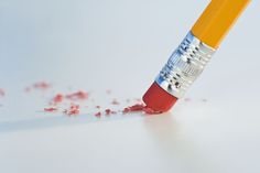 a pencil with red crayons sticking out of it's tip on a white surface