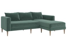 a green couch with pillows on it and a wooden leg rest in front of the couch