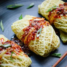 some dumplings are sitting on a plate with chopsticks