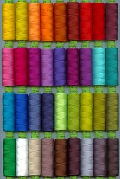 the spools of thread are lined up in rows and on display with each color