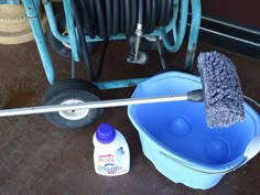 a mop, bucket and cleaning supplies sitting on the floor