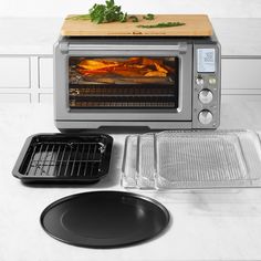 a toaster oven sitting on top of a counter next to a tray with food in it