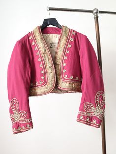 "Antique 1920s French theatre costume bolero jacket. Fuchsia pink wool. Gold and peach woven floral ribbon trim. Silver metal thread applied ribbon with interspersed rhinestone embellishments. A treasure made by costumier Aristide Boyer, Marseille. Measures: 20\" underarm to underarm, 16\" shoulders, 22\" sleeves, 16\" long from shoulder to hem  Condition: freshly laundered by hand with cold water and a gentle detergent. Some missing rhinestones. Repairs at the back of the underarm areas as show Pink Fitted Embroidered Outerwear, Pink Embroidered Fitted Outerwear, Vintage Fitted Outerwear For Festive Occasions, Pink Embroidered Outerwear For Wedding, Pink Embroidered Wedding Outerwear, Fitted Pink Outerwear For Festive Occasion, Pink Fitted Outerwear For Wedding, Fitted Pink Outerwear For Wedding, Ribbon Jacket