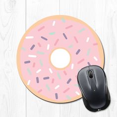 a blue donut with sprinkles is next to a computer mouse pad