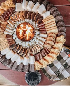 a platter filled with lots of different types of cookies and crackers on top of a wooden table