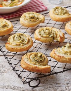 there are many small pastries on the cooling rack next to some bowls of food