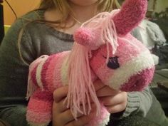 a woman holding a pink and white stuffed animal