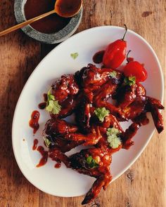 a white plate topped with chicken wings covered in sauce