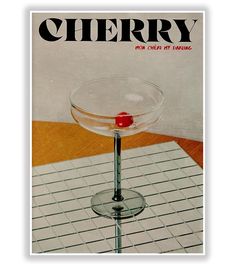 a magazine cover with a martini glass sitting on top of a table next to a red object