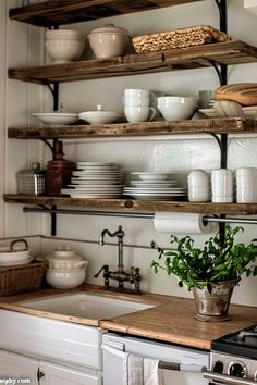 a kitchen filled with lots of white plates and bowls on top of shelves above a stove