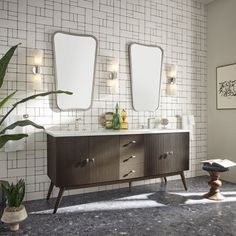 a bathroom with two sinks and mirrors on the wall