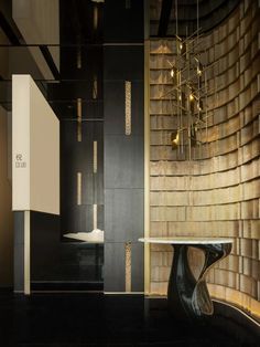 a black and gold room with a table, chandelier and mirror on the wall