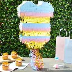 a table topped with cupcakes covered in frosting next to a cake bag