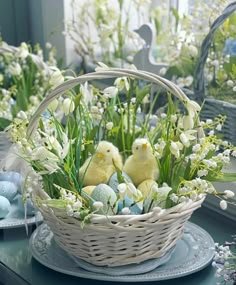 a basket filled with eggs sitting on top of a table next to flowers and other decorations