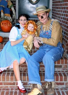 there is a man and woman sitting on the steps with a doll in front of them