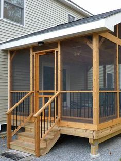 a screened porch in front of a house with wooden steps and railings on the side