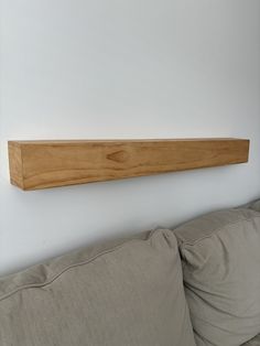 a wooden shelf mounted on the wall above a couch