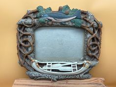 an ornate silver frame with a fish and leaves on the front is sitting on top of a book