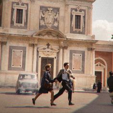 two men are walking in front of a building