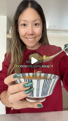 a woman is holding a bowl with food in it