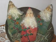 three gnomes sitting on top of a potted plant in the middle of some hay