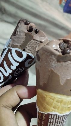 two ice cream cones with chocolate toppings on them