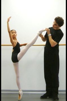 a man and woman in ballet clothes standing next to each other