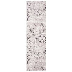 a white and black runner rug with an abstract design on the bottom, in front of a