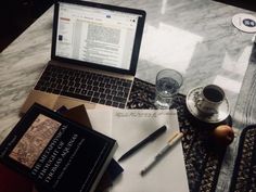 an open laptop computer sitting on top of a table next to a cup of coffee