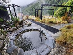 an outdoor hot tub surrounded by rocks and water