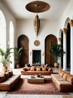 a living room filled with lots of couches and tables in front of large windows